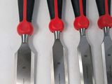 six knives are lined up on a white surface with a red handle