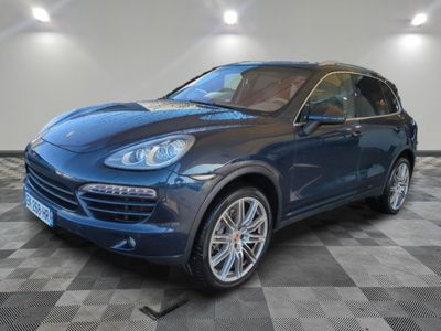 a blue porsche cayen is parked in a room with a checkered floor
