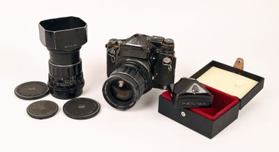 un appareil photo et quelques pièces de monnaie dans une boîte posée sur une surface blanche