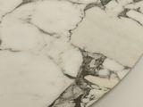 a close up of a white marble surfboard on a white surface