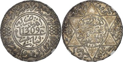 a silver coin with arabic writing on it