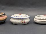 three small ceramic containers are lined up next to each other