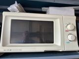 a microwave sitting on top of a blue shelf