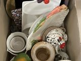 une boîte remplie d'assiettes et de tasses posée par terre