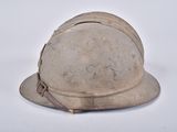 an old helmet sitting on top of a table on a white surface