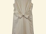 the back of a white dress with a large bow on a hanger