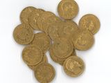 une pile de pièces d'or posée sur une surface blanche