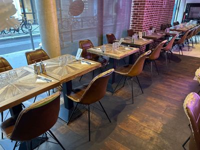 des tables et des chaises dans un restaurant, avec un mur en briques en arrière-plan