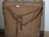 a wooden box with a rope around it on a tile floor