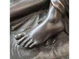 a close up of a bronze statue of a woman ' s feet