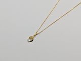 un collier en or avec un pendentif en forme de larme suspendu à une chaîne