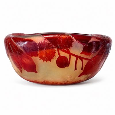 un bol rouge et jaune orné de fleurs et de feuilles