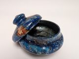 a blue bowl with a lid sitting on a white surface