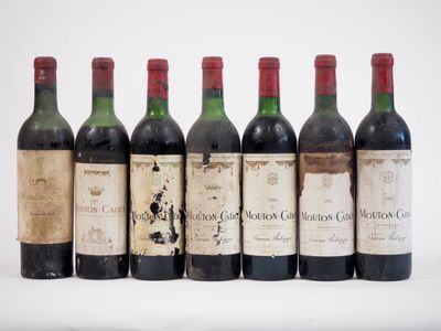 six bouteilles de vin sont alignées sur une surface blanche