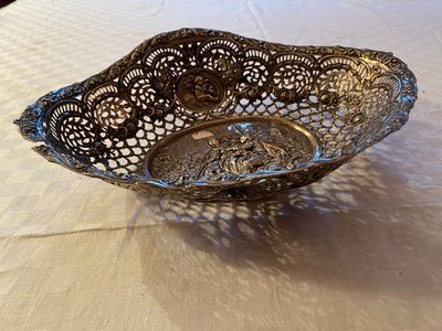 an image of a silver bowl on a table with a white table cloth