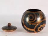 un vase noir et doré, avec un couvercle à côté