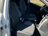 une voiture blanche dont la portière est ouverte et les sièges rabattus