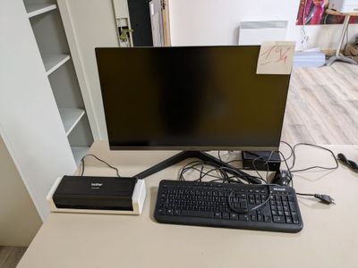 une photo d'un bureau d'ordinateur avec un clavier et un écran