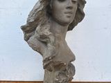 sculpture représentant la tête d'une femme aux longs cheveux, posée sur une table en bois