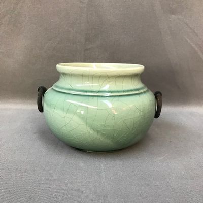 un vase vert posé sur une table