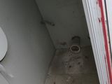 a small bathroom with a toilet and a dirty floor
