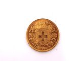 a close up of a gold coin on a white surface