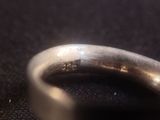 a close up of a silver ring on a black surface