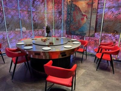 de nombreuses chaises rouges disposées autour d'une table ronde dans un restaurant