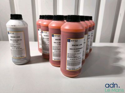 quatre flacons d'encre posés les uns à côté des autres sur une table