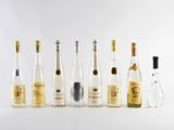 plusieurs bouteilles d'alcool sont alignées sur une surface blanche