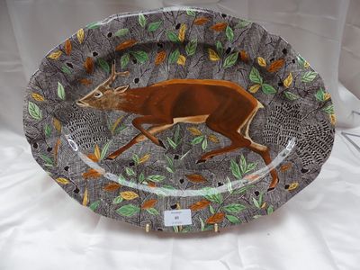 une assiette sur laquelle est représenté un cerf, posée sur une table