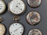 several different types of pocket watches are displayed on a gray surface