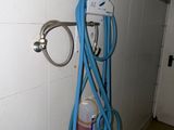 a blue hose attached to a wall in a bathroom