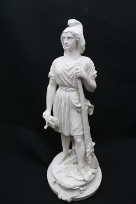 statue d'une femme tenant un bâton et portant un chapeau, sur fond noir