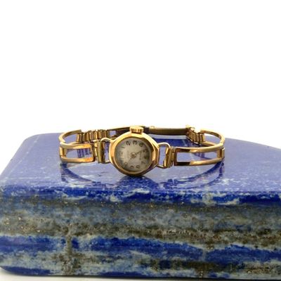 bracelet watch on a blue marble block with a white background