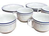 six white and blue coffee mugs sitting on top of each other