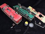 three toy trains are sitting next to each other on a black surface