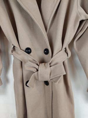 a close up of a coat on a hanger on a white wall