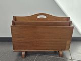 an old wooden magazine rack sitting on top of a tiled floor