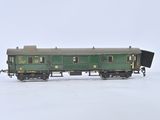 a green train car sitting on the tracks in the snow