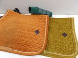 two saddle pads and a blow dryer sitting on a table