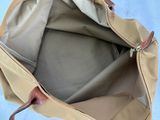 the inside of a tan bag with a brown handle