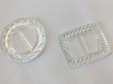 two silver buckles on a white table cloth