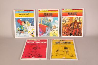 quatre bandes dessinées sont alignées les unes à côté des autres sur une table