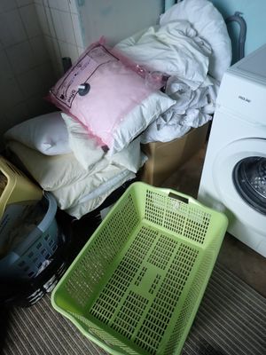 un panier à linge et une machine à laver dans une petite pièce