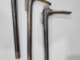 three old tools that are hanging on the wall