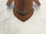un casque marron posé sur un drap blanc sur un lit