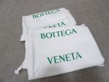 two white towels with green writing on them sitting on a table