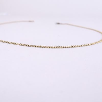 un collier ras-du-cou à chaîne en or sur fond blanc