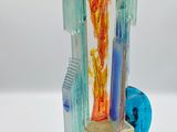 a glass sculpture of a robot on a glass plate